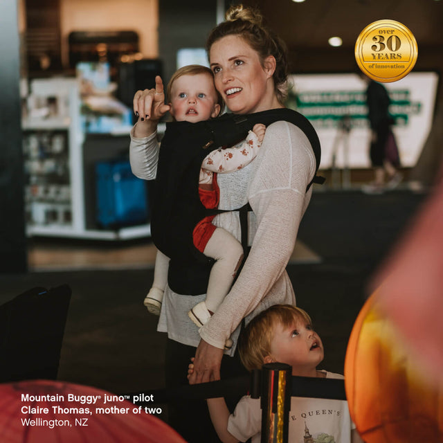 maman portant son enfant dans le sac de transport juno™ en position face au parent - Mountain Buggy juno™  pilot Claire Thomas, mère de deux enfants, Wellington, Nouvelle-Zélande
