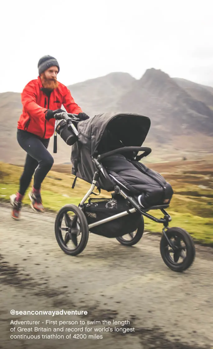 Mountain Buggy terrain all terrain 3-wheel stroller with sleeping bag – dad running on a mountain trail